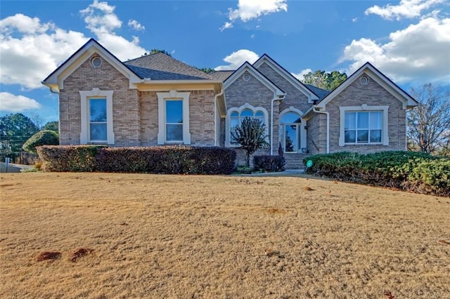 single story home featuring brick siding and a front lawn