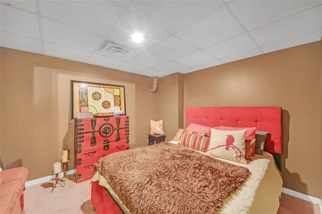 bedroom with carpet floors, visible vents, baseboards, and a drop ceiling