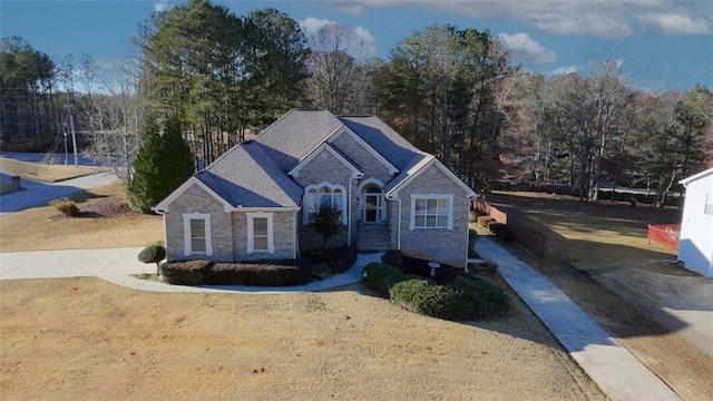 view of front facade featuring driveway and stone siding