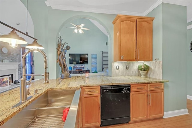 kitchen featuring a warm lit fireplace, dishwasher, ornamental molding, light stone countertops, and a sink