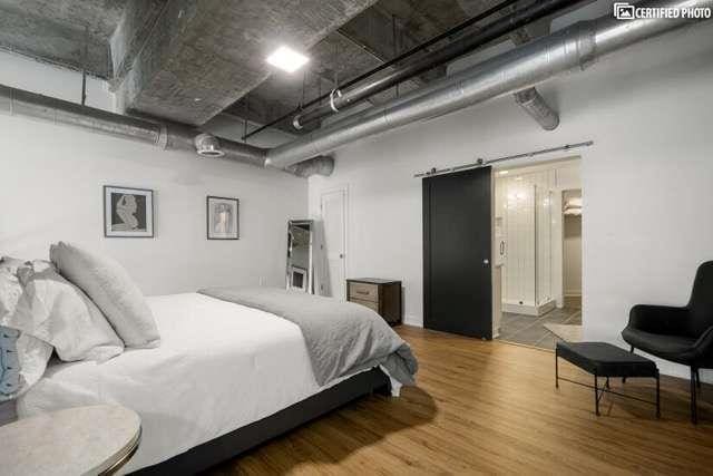 bedroom featuring hardwood / wood-style flooring and a barn door