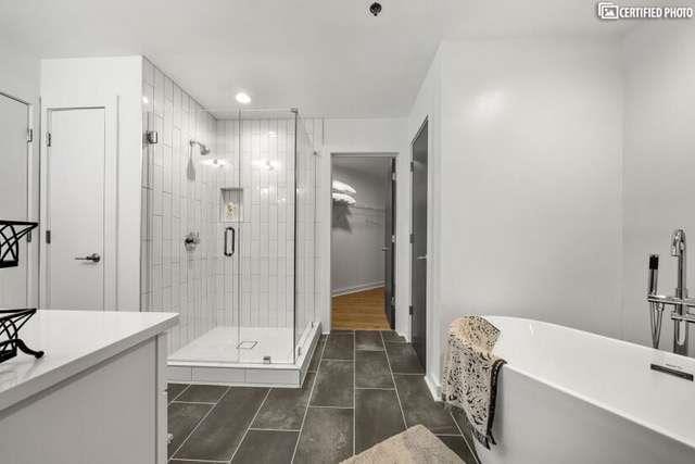 bathroom featuring independent shower and bath, vanity, and tile patterned flooring