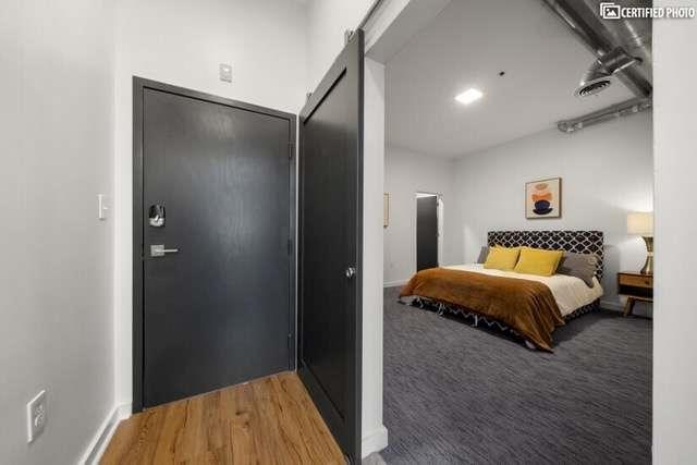 bedroom with wood-type flooring and a barn door