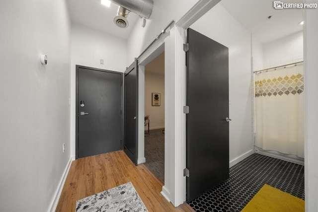 corridor featuring wood-type flooring and a barn door