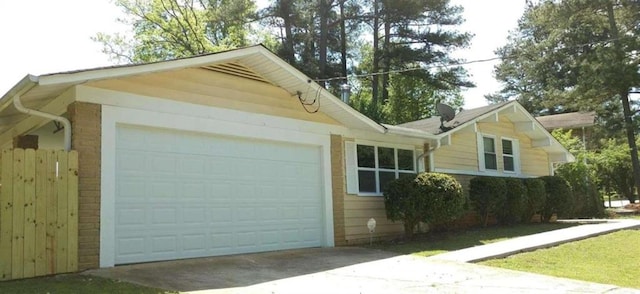 view of property exterior with a garage, driveway, and brick siding