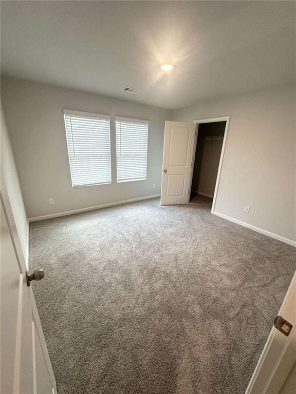 unfurnished bedroom featuring visible vents, baseboards, and carpet floors