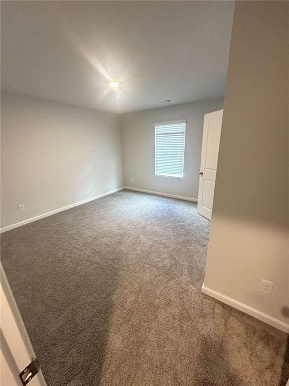 carpeted empty room featuring baseboards