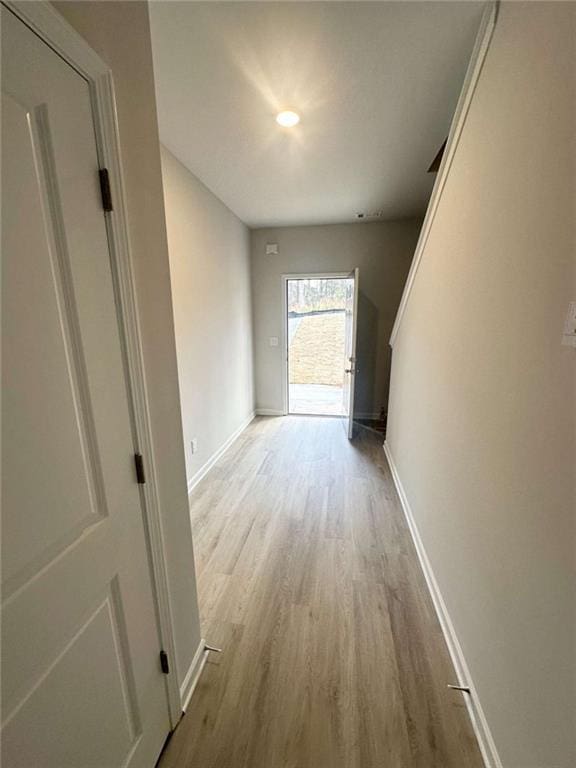 hall featuring baseboards and wood finished floors