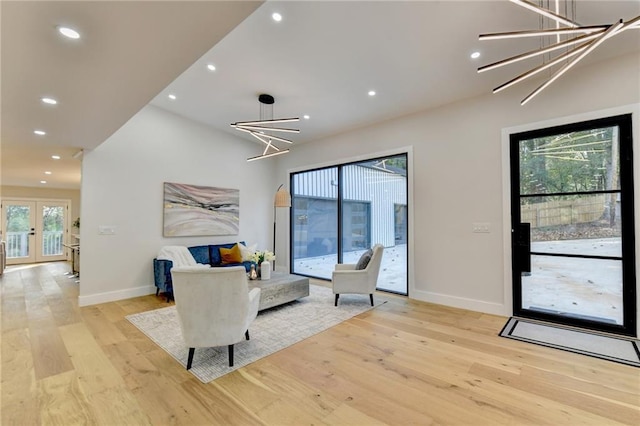 living room featuring light hardwood / wood-style floors, an inviting chandelier, and plenty of natural light