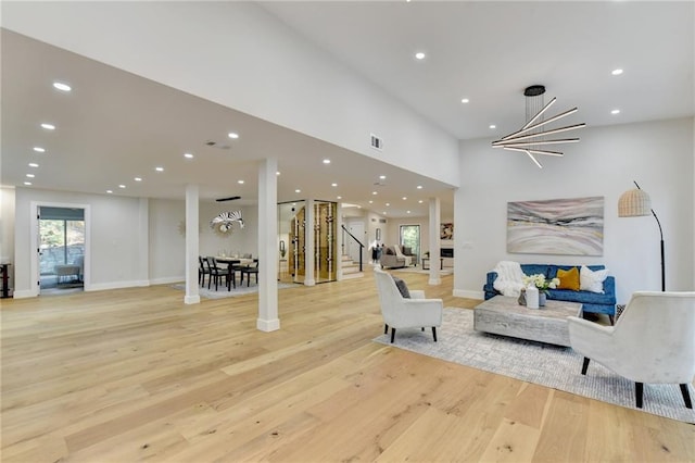 living room with a chandelier and light wood-type flooring