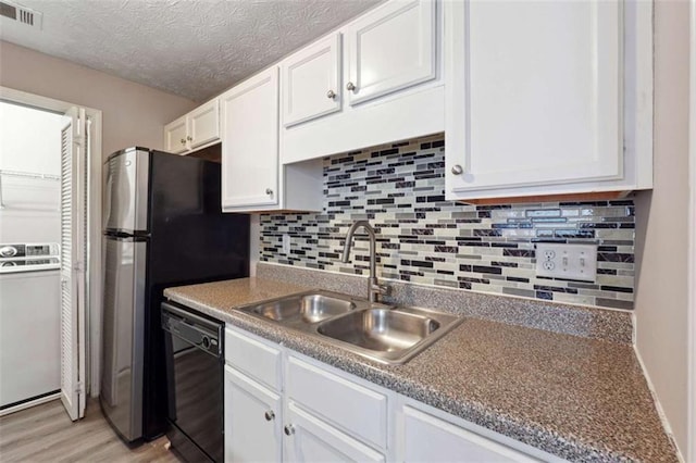 kitchen with sink, white cabinetry, a textured ceiling, black dishwasher, and light hardwood / wood-style floors