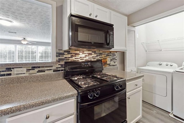 kitchen with white cabinets, ceiling fan, light wood-type flooring, washer and clothes dryer, and black appliances