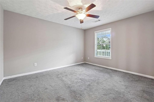 carpeted spare room featuring a textured ceiling and ceiling fan