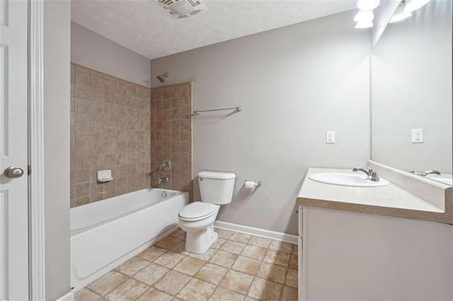 full bathroom featuring toilet, a textured ceiling, tiled shower / bath, and vanity