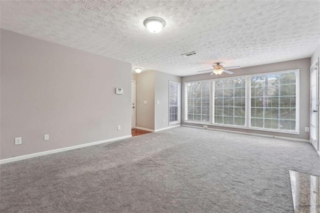 unfurnished room featuring ceiling fan, carpet, and a textured ceiling