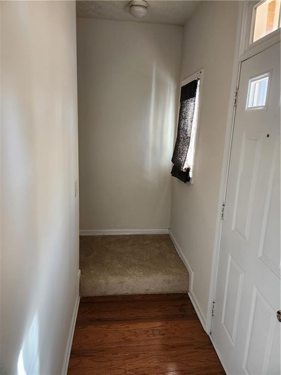 hallway featuring wood finished floors and baseboards