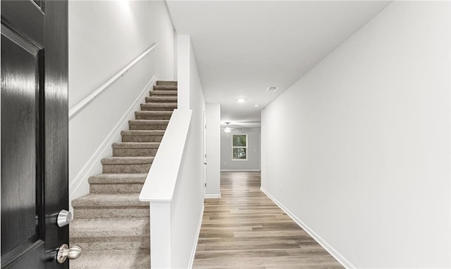 stairs with a ceiling fan, baseboards, and wood finished floors