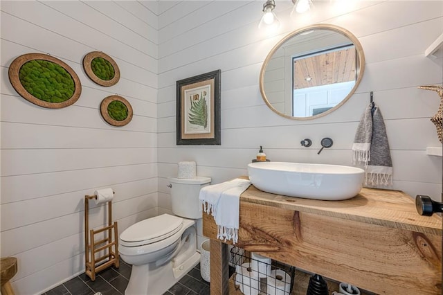 6301 New Bethany Rd, Buford, GA 30518 - half bathroom featuring a sink, toilet, tile patterned flooring, and wood walls