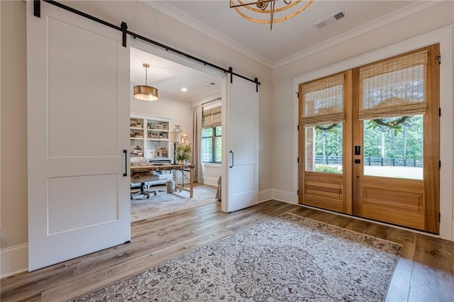 6301 New Bethany Rd, Buford, GA 30518 - entryway with a barn door, wood finished floors, crown molding, and baseboards