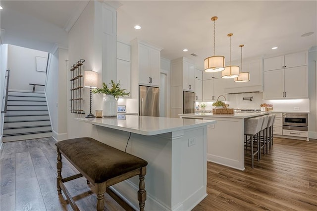 6301 New Bethany Rd, Buford, GA 30518 - kitchen featuring appliances with stainless steel finishes, a breakfast bar area, a peninsula, dark wood finished floors, and recessed lighting