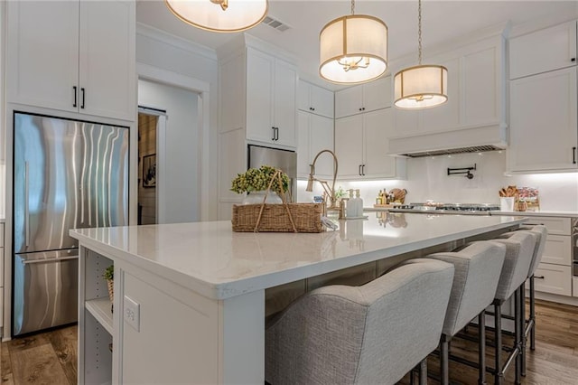 6301 New Bethany Rd, Buford, GA 30518 - kitchen featuring appliances with stainless steel finishes, white cabinets, wood finished floors, and ornamental molding