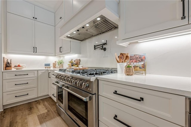 6301 New Bethany Rd, Buford, GA 30518 - kitchen featuring double oven range, premium range hood, white cabinets, light countertops, and light wood-style flooring