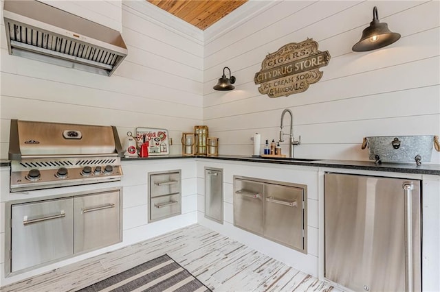 6301 New Bethany Rd, Buford, GA 30518 - kitchen featuring a sink, wall chimney range hood, refrigerator, wood walls, and dark countertops