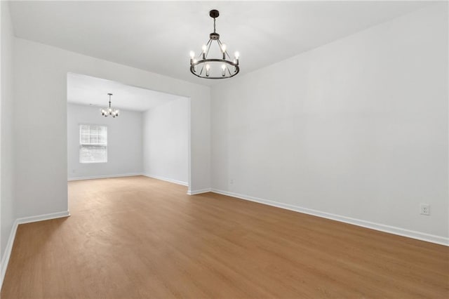 empty room featuring hardwood / wood-style floors and an inviting chandelier