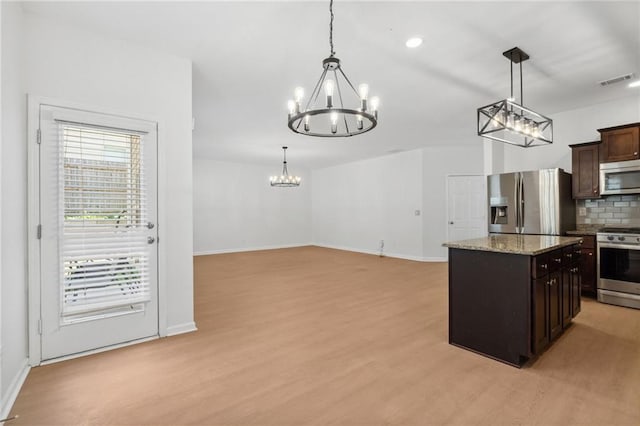 kitchen featuring decorative light fixtures, dark brown cabinetry, decorative backsplash, and stainless steel appliances