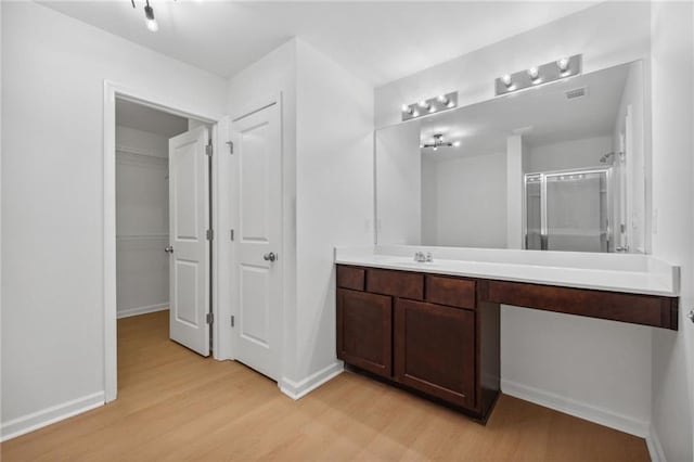 bathroom featuring vanity, a shower with shower door, and hardwood / wood-style flooring