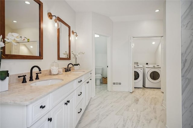 bathroom with washer and dryer, toilet, and vanity