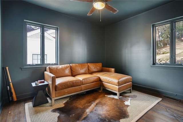 living room featuring ceiling fan and dark hardwood / wood-style flooring