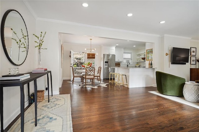 living room with ornamental molding, dark wood-type flooring, and sink