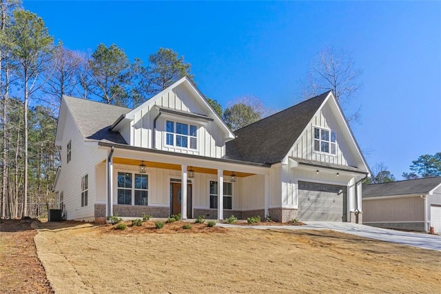 view of front of house featuring central AC unit, covered porch, and a garage