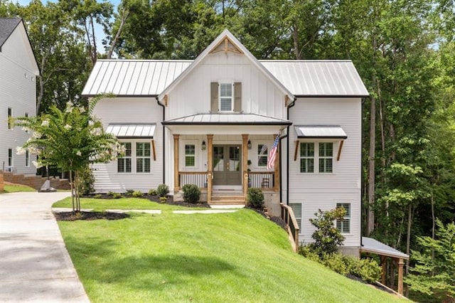 modern farmhouse featuring a front lawn, a porch, and french doors