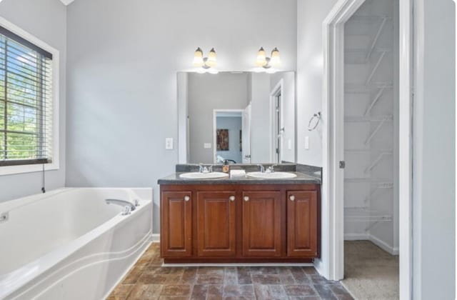 bathroom with vanity and a tub to relax in