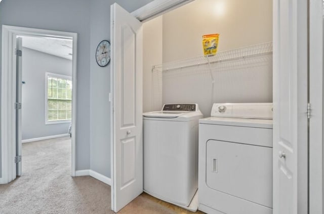 laundry room with light colored carpet and washer and dryer