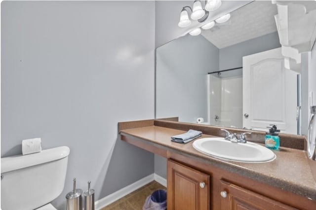 bathroom featuring vanity, a textured ceiling, a shower, tile patterned floors, and toilet