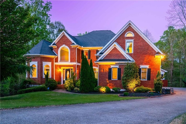 view of front of house with a yard and brick siding
