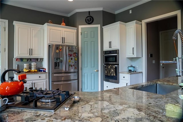 kitchen featuring stainless steel appliances, light stone countertops, white cabinetry, and decorative backsplash