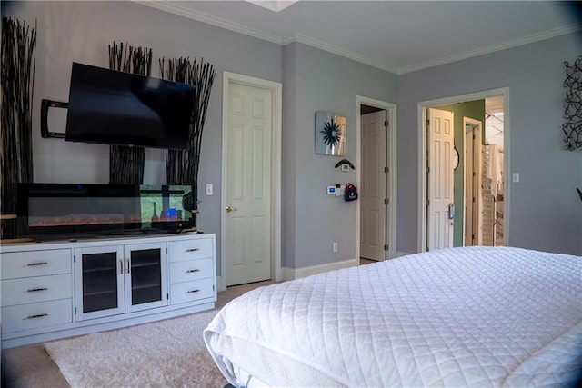 carpeted bedroom featuring crown molding and baseboards