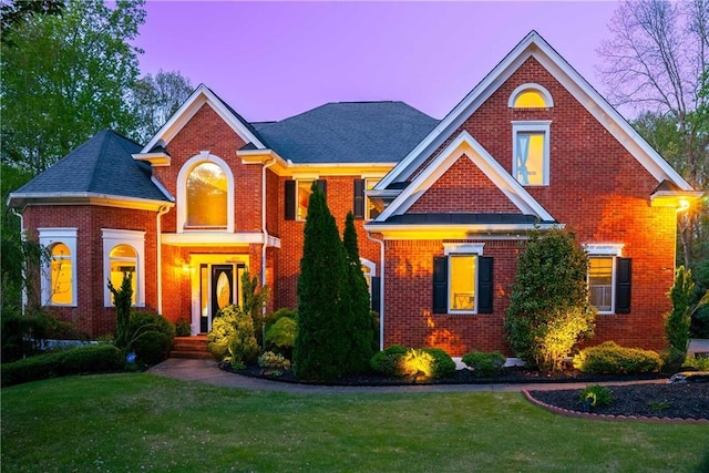 view of front of home with a front yard and brick siding
