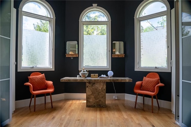sitting room with wood finished floors, baseboards, and built in study area