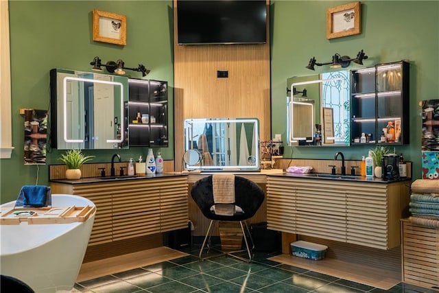 interior space with a sink, tile patterned floors, and a freestanding tub