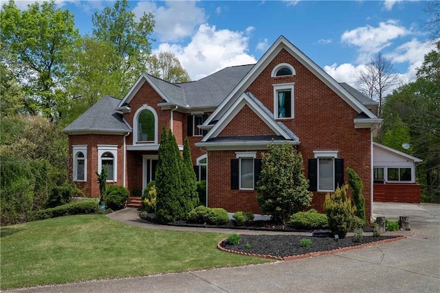 view of front of property featuring a front lawn and brick siding