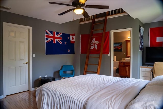 bedroom featuring visible vents, baseboards, ceiling fan, hardwood / wood-style flooring, and ensuite bath