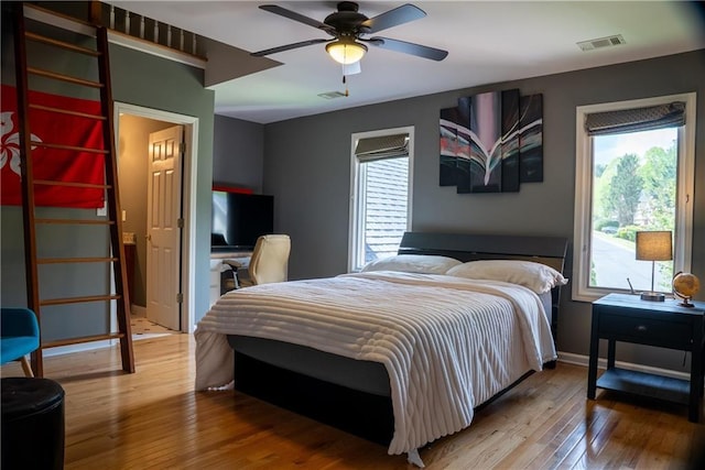 bedroom with visible vents, hardwood / wood-style flooring, baseboards, and ceiling fan