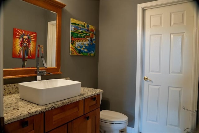 half bath featuring vanity and toilet