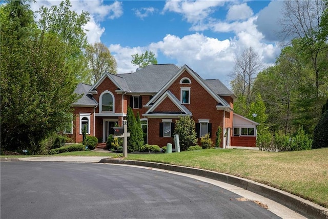 view of front of house with brick siding and a front lawn