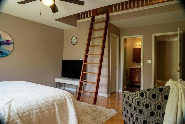 bedroom with wood finished floors, baseboards, and connected bathroom
